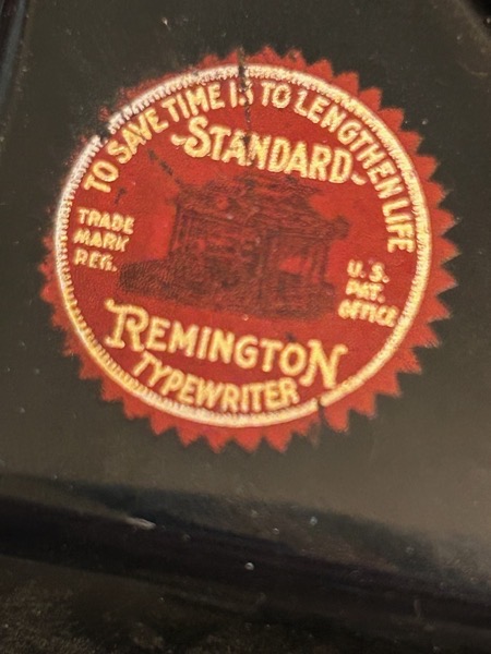 Extreme close up of Remington Portable typewriter sticker that says, 'To save time is to lengthen life.'